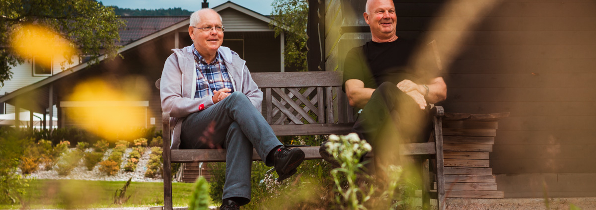 Egil Skogestad og Ånen Werdal sitter på en benk ved Lygnevann og smiler